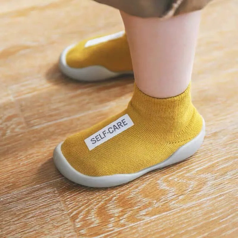 Adorable baby wearing soft, non-slip crib shoes.  Safe & comfy booties for crawling & playtime.