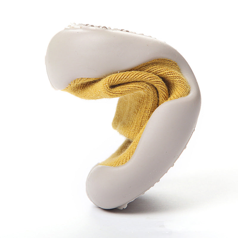 Adorable baby wearing soft, non-slip crib booties.  Safe and comfy for crawling and playtime.  Perfect baby shower gift!