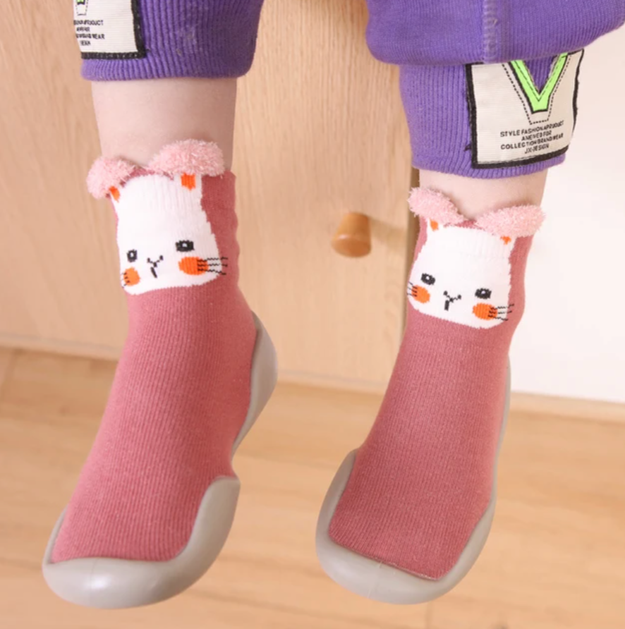 Adorable baby wearing soft, non-slip crib shoes.  Safe and comfy booties for crawling and playtime.  Perfect baby shower gift!