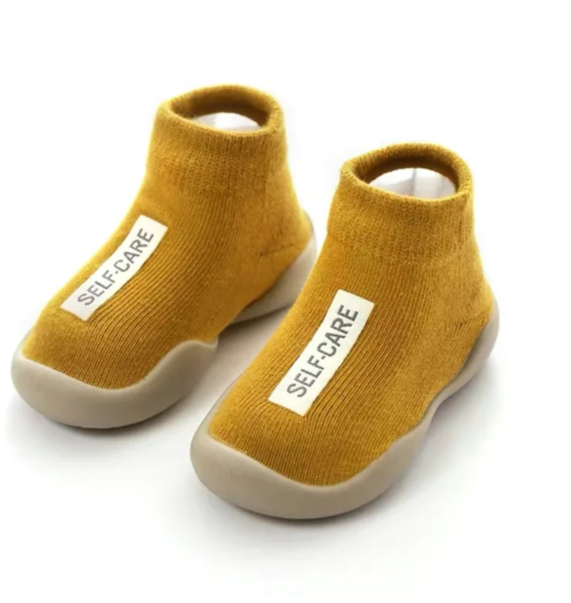 Adorable baby wearing soft, non-slip crib shoes.  Safe and comfy booties for crawling and playtime.